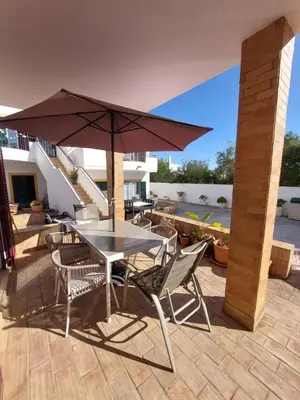 a table and chairs with an umbrella on a patio at Casa Luna, Burgau - Luz, Lagos in Burgau