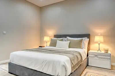 a bedroom with a large bed with two lamps at Tristão Vaz I, a Home in Madeira in Machico