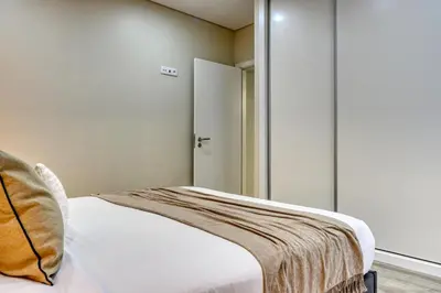 a bedroom with a bed and a closet with a door at Tristão Vaz I, a Home in Madeira in Machico