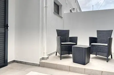 three chairs and a table on a balcony at Tristão Vaz I, a Home in Madeira in Machico