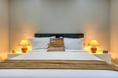 a bedroom with a large bed with two lamps at Tristão Vaz II, a Home in Madeira in Machico