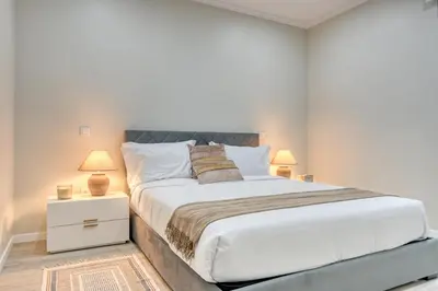 a bedroom with a large bed and two lamps at Tristão Vaz II, a Home in Madeira in Machico