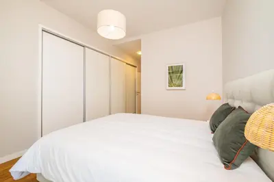a bedroom with a large white bed with green pillows at Apartment with ocean view and parking in Funchal