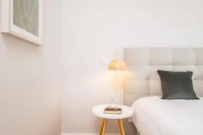 a bedroom with a bed and a table with a lamp at Apartment with ocean view and parking in Funchal