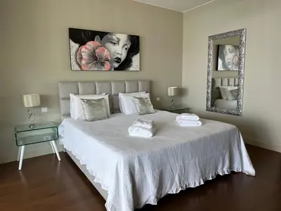 a bedroom with a large white bed with a mirror at Madeira Palace Residences in Funchal