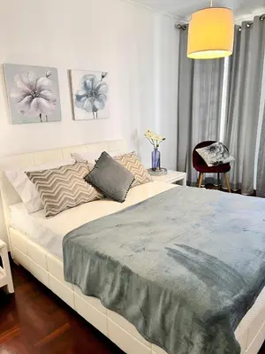 a bedroom with a white bed with a blue blanket at Stay In Madeira in Funchal