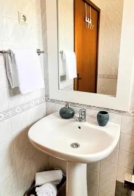 a bathroom with a sink and a mirror and towels at Stay In Madeira in Funchal