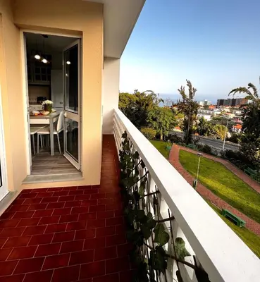 a balcony with a table and a view of the city at Stay In Madeira in Funchal