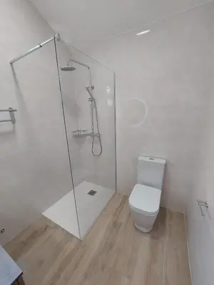 a bathroom with a toilet and a glass shower at The Passion Fruit House in São Vicente