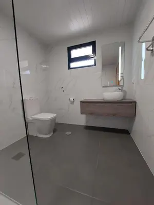 a bathroom with a toilet and a sink and a mirror at The Passion Fruit House in São Vicente