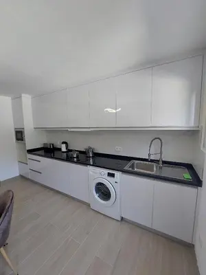 a kitchen with a sink and a washing machine at The Passion Fruit House in São Vicente