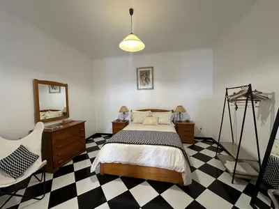 a bedroom with a bed and a dresser and a mirror at Residência Mendonça in Faial