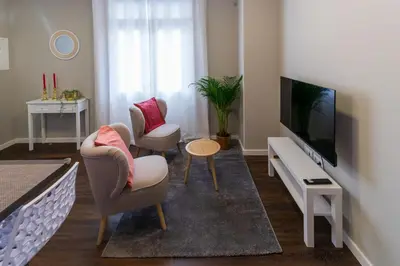 a living room with two chairs and a flat screen tv at Blue House in Ponta do Sol