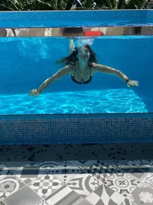 a woman is swimming in a swimming pool at Blue House in Ponta do Sol