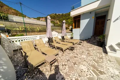 a group of chairs and umbrellas on a patio at Blue House in Ponta do Sol