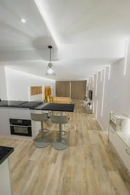 a kitchen and living room with a table and a couch at Sea Breeze III in Caniço