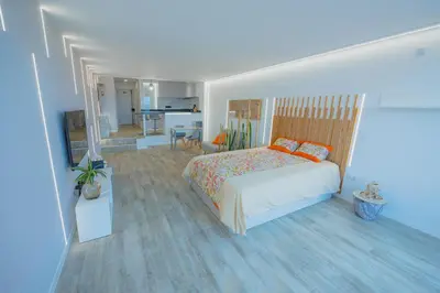 a bedroom with a bed and a living room at Sea Breeze III in Caniço