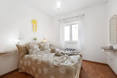 a bedroom with a bed with white walls and a window at Casa Branca in Luz