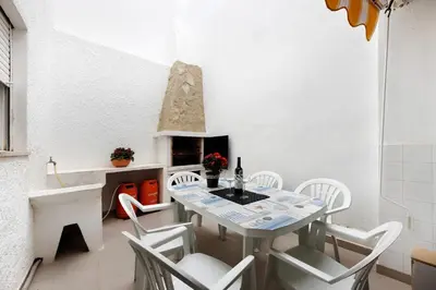 a dining room with a table and chairs and a fireplace at Casa Branca in Luz