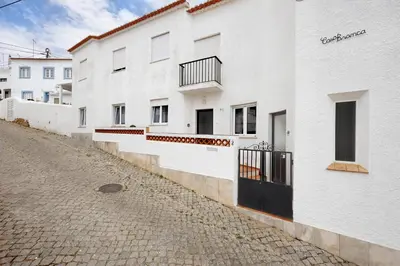 a row of white buildings on a cobblestone street at Casa Branca in Luz
