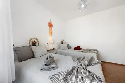 two beds in a room with white walls at Casa Branca in Luz