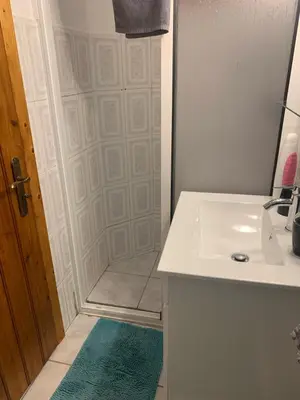a white bathroom with a sink and a shower at Waves Song - Cottage in Porto Moniz