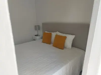 a white bed with two orange pillows on it at Alexia Room in Funchal