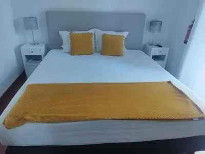 a bed with two pillows and a yellow blanket on it at Alexia Room in Funchal