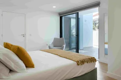 a bedroom with a large bed and a chair at GuestReady - Hillside Oceanview Heaven in Funchal