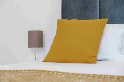 a yellow pillow sitting on top of a bed at GuestReady - Hillside Oceanview Heaven in Funchal