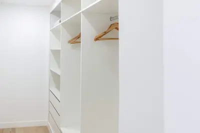 a walk in closet with white walls and shelves at GuestReady - Hillside Oceanview Heaven in Funchal