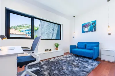an office with a blue chair and desk and a window at Serenity by the Sea in Funchal