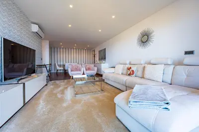 a living room with a white couch and a television at Serenity by the Sea in Funchal