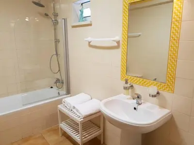 a bathroom with a sink and a mirror and a tub at Entire flat 70sq m at Luz just 400m beach distance in Luz