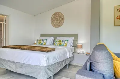 a bedroom with a bed and a blue chair at Studio 92, a Home in Madeira in Ponta do Sol