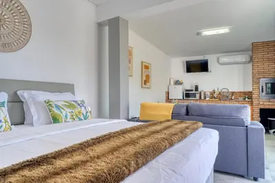 a bedroom with a large bed and a blue couch at Studio 92, a Home in Madeira in Ponta do Sol