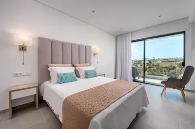 a bedroom with a large bed and a large window at Vila Luna B&B in Lagos
