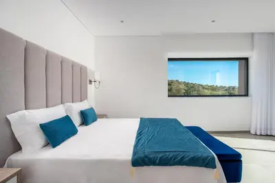 a bedroom with a large white bed with blue pillows at Vila Luna B&B in Lagos