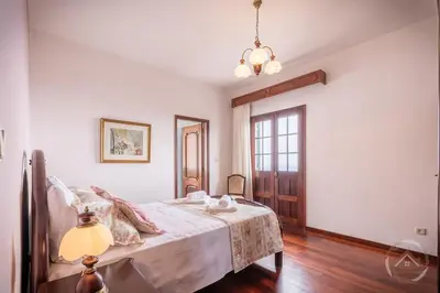a bedroom with a bed and a lamp in it at Garden House in Funchal