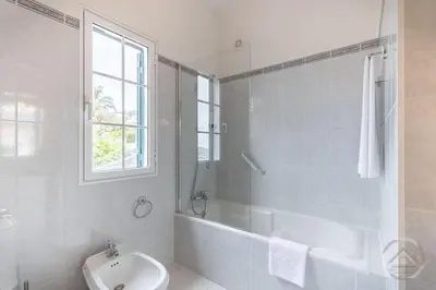 a white bathroom with a tub and a sink at Garden House in Funchal