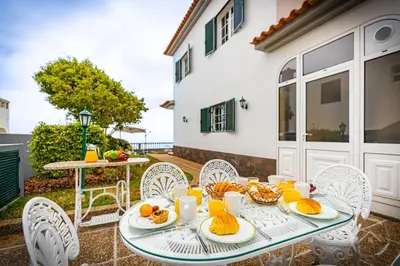 a table with plates of food on a patio at Garden House in Funchal