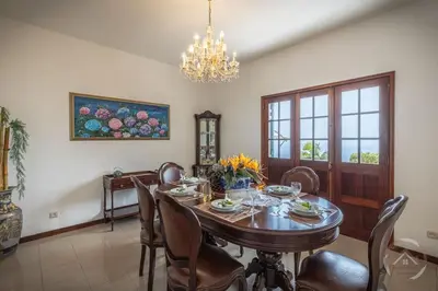 a dining room with a table and chairs and a chandelier at Garden House in Funchal
