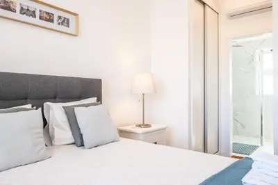 a bedroom with a bed with white pillows and a lamp at Villa Ana D'Arfet in Água de Pena
