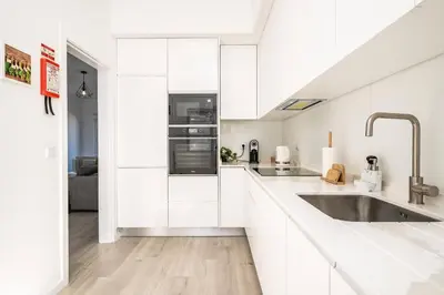 a kitchen with white cabinets and a sink at Villa Ana D'Arfet in Água de Pena