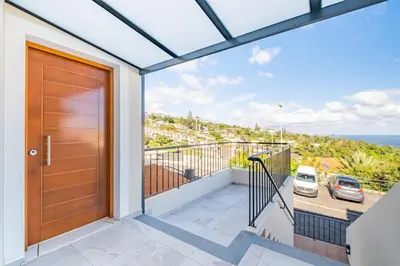 a door to a balcony with a view of the ocean at Villa Ana D'Arfet in Água de Pena