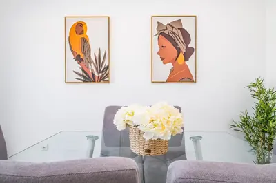 a living room with two chairs and a vase of flowers at Villa Ana D'Arfet in Água de Pena