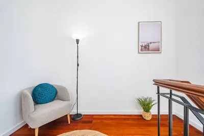 a living room with a chair and a lamp at Villa Ana D'Arfet in Água de Pena