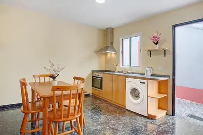 a kitchen with a table and a washing machine at São Vicente House in São Vicente