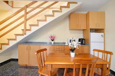 a kitchen with a wooden table and a staircase at São Vicente House in São Vicente