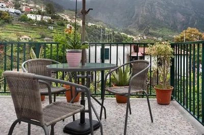 a table and chairs on a balcony with a view at São Vicente House in São Vicente